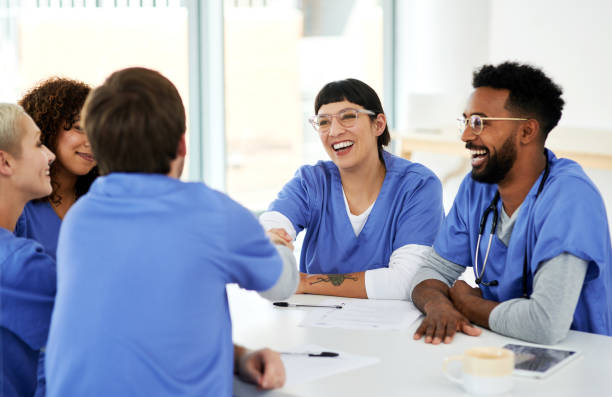 Shot of a young doctor shaking hands with her colleague during a meeting in a hospital